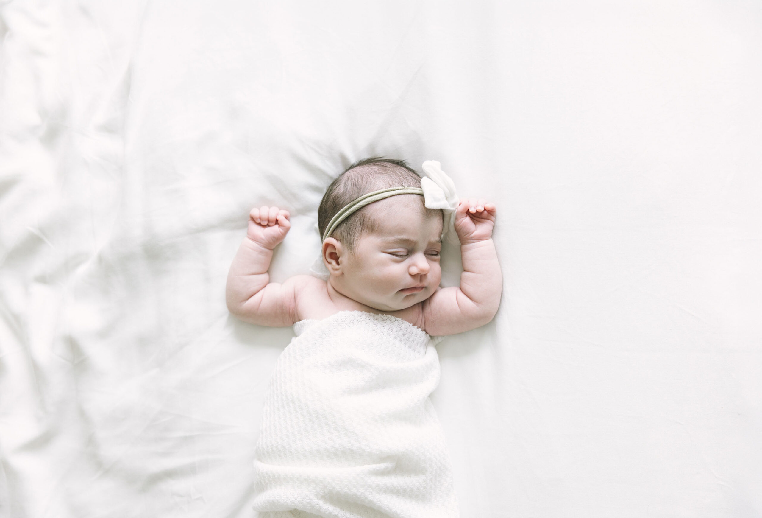 baby girl lying on a white blanket