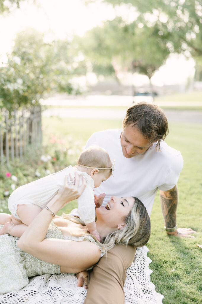 family playing on the grass with their baby girl