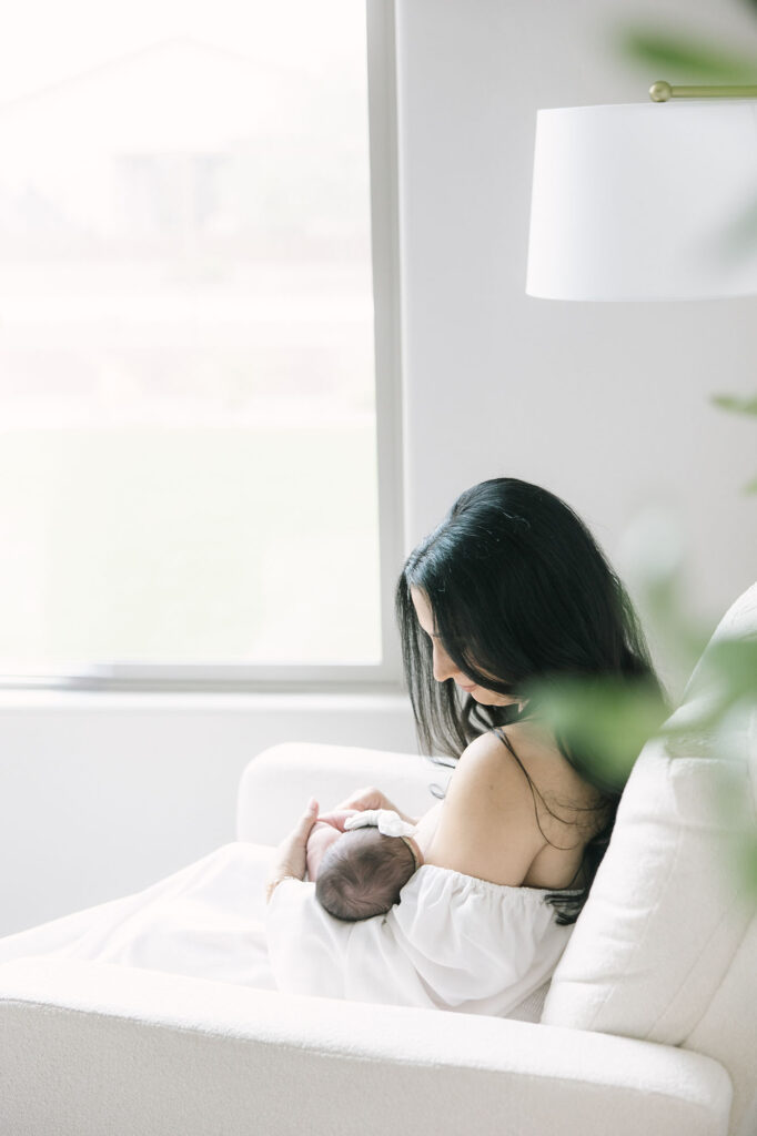 mom nursing her baby while sitting in a chair